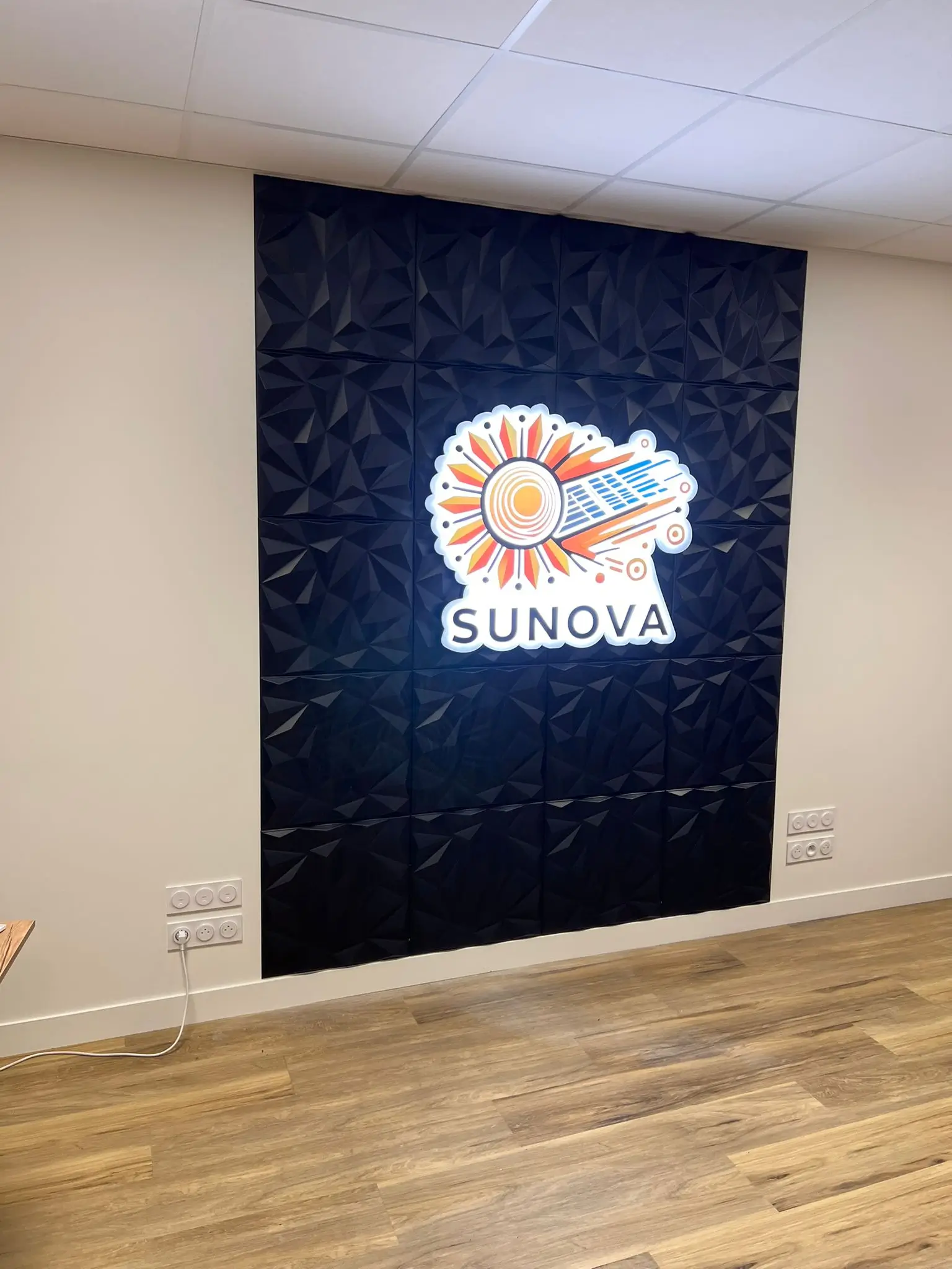 Enseigne lumineuse Sunova sur mur 3D texturé – réalisation ID Graphic