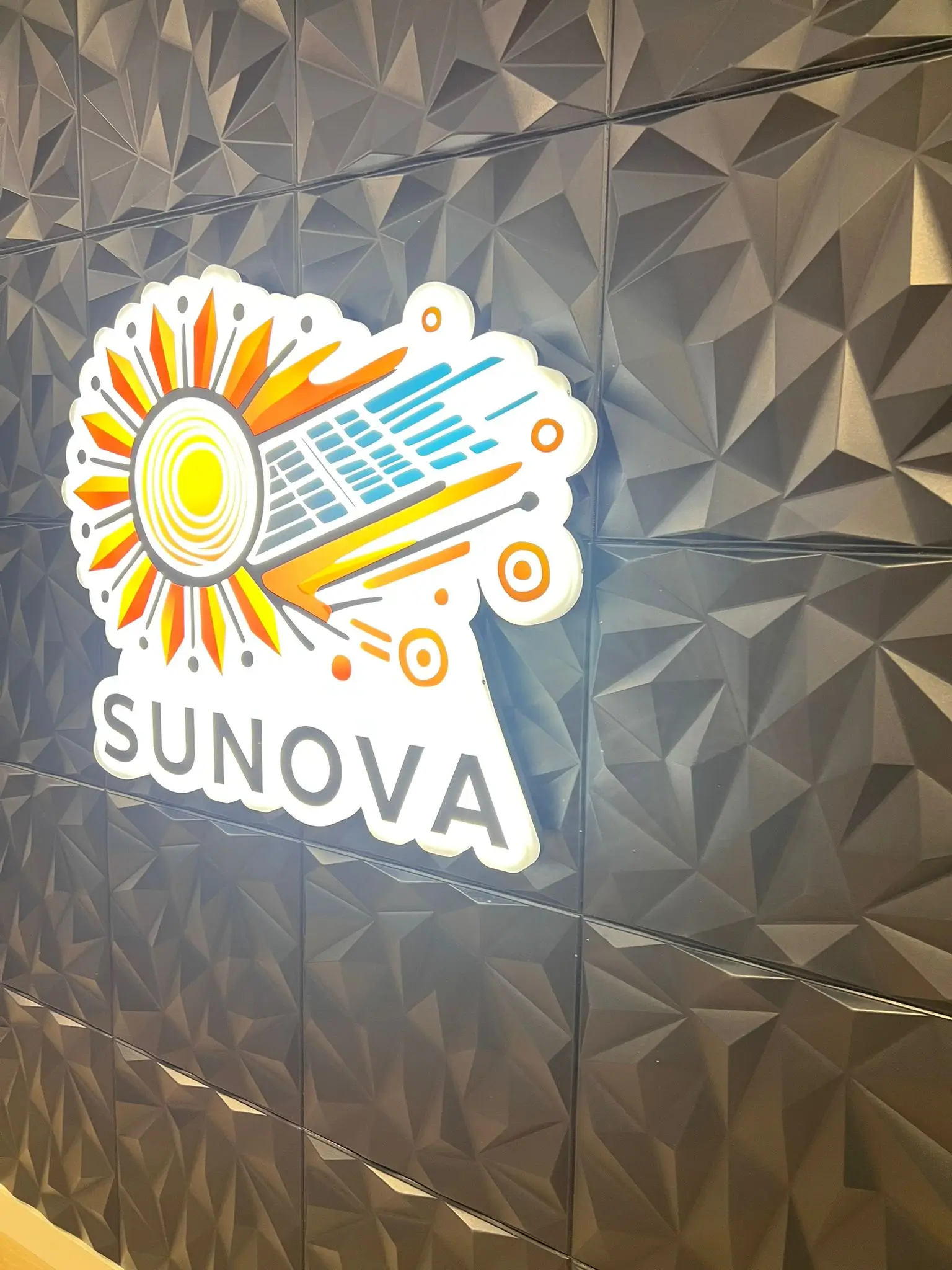 Vue latérale de l’enseigne lumineuse Sunova sur mur 3D – ID Graphic